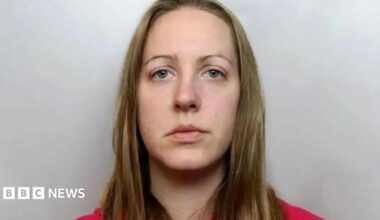 Custody image of Lucy Letby, who has long blonde hair and is wearing a red top.