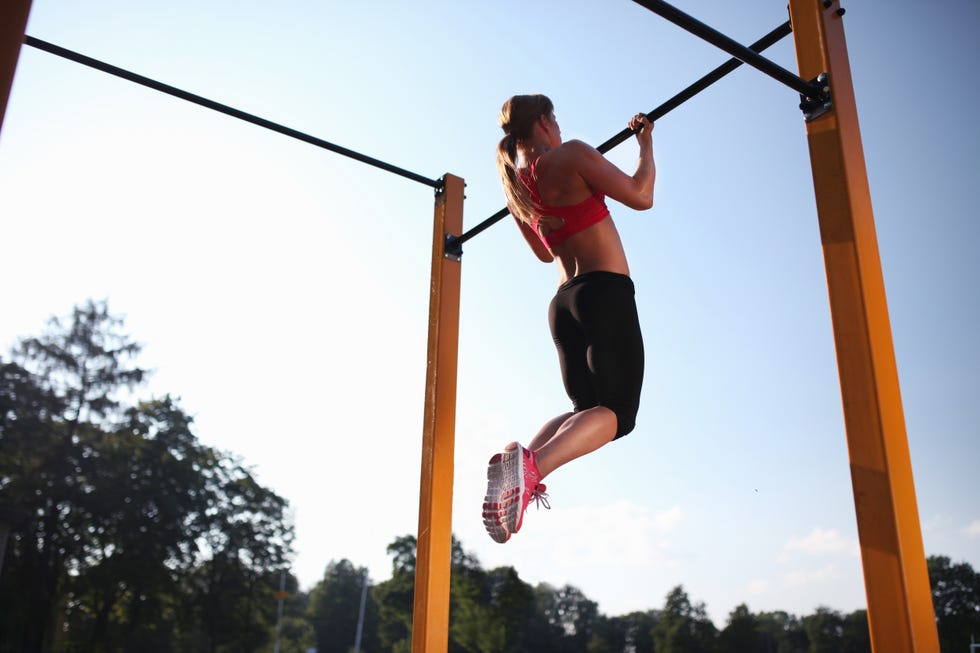 Girl training on chin-up bar outdoor