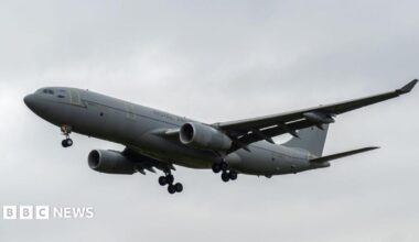 A grey RAF Voyager seen flying through cloudy skies