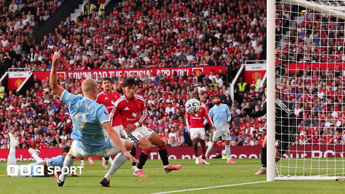 Erling Haaland of Manchester City speaks with referee Michael Oliver as a VAR check is performed after his goal is initially ruled offside