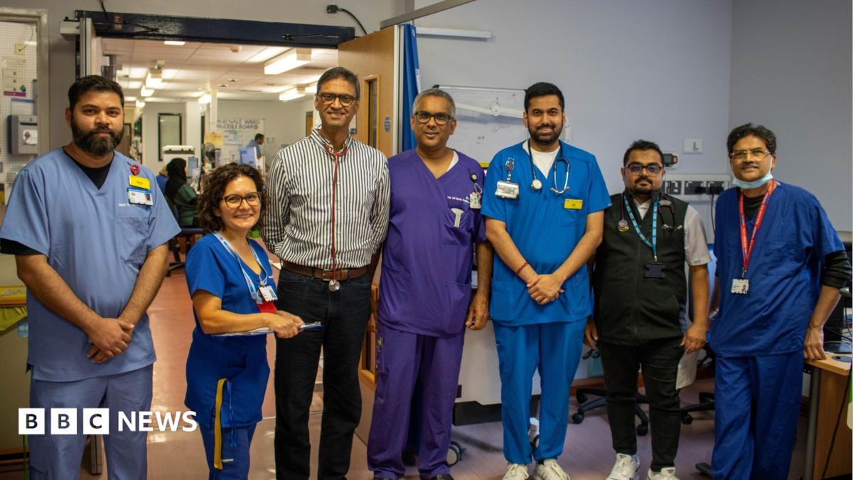 A group of doctors dressed in scrubs, shirts and a gilet.
