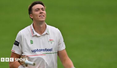 Josh Hull raises his bat to celebrate his half-century