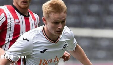 Dan Watts is playing for Swansea in their white home kit.