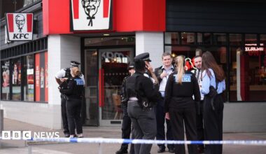 Police stand nearby to the KFC