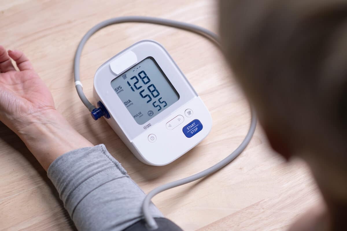 Middle-aged woman checks blood pressure monitor and heart rate