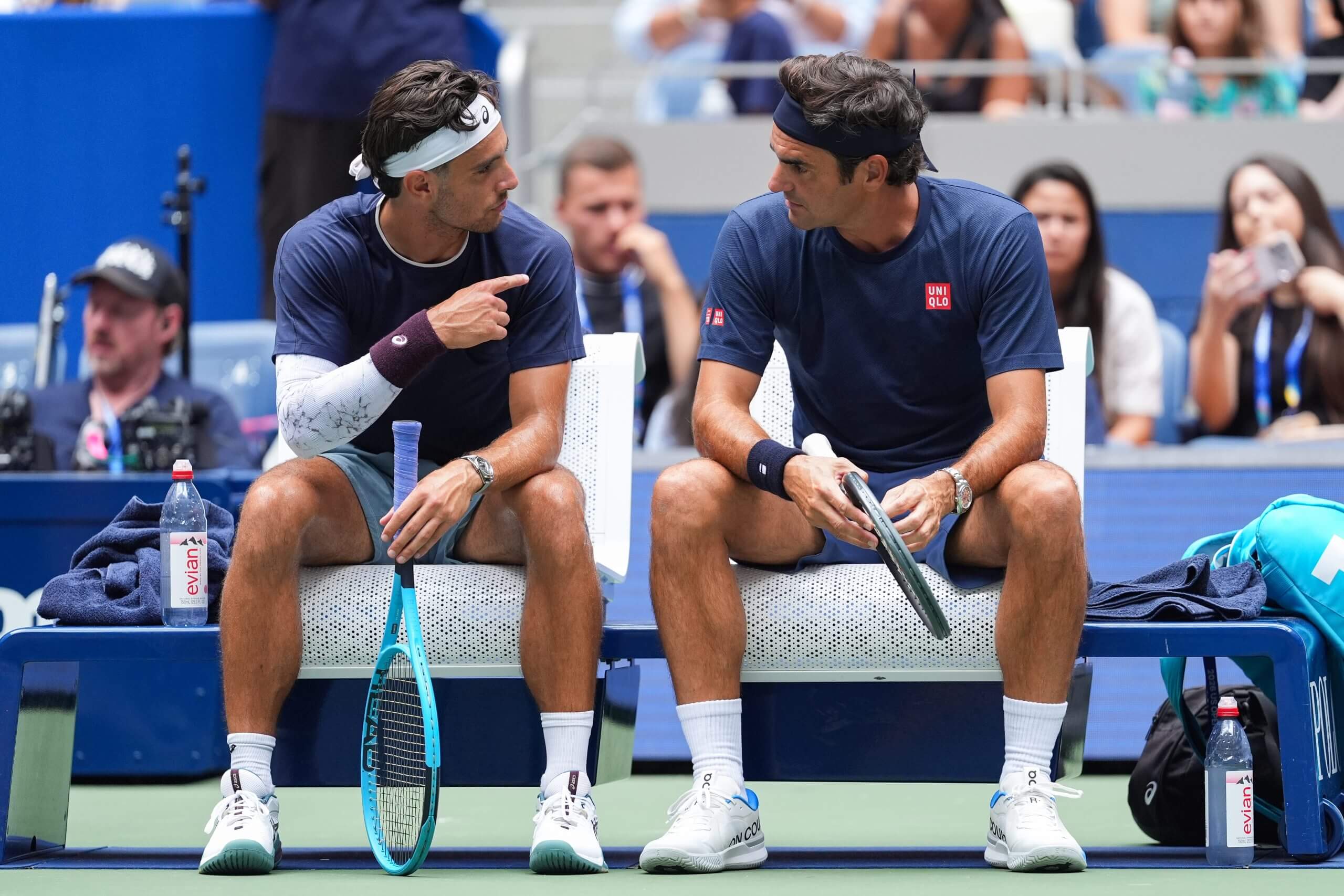 Lorenzo Musetti points at Roger Federer with his right hand.