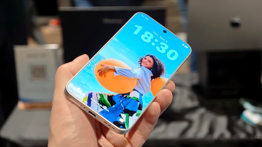 Prakhar Khanna holding the Tecno Next-Gen Bezelless Concept Phone  with its screen turned on.