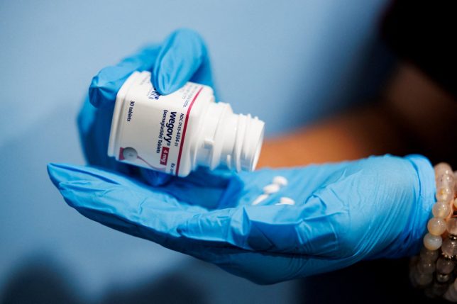 FILE PHOTO: A person poses with a bottle of Wegovy (semaglutide) tablets in this illustration picture taken in Schwenksville, Pennsylvania, U.S. June 16, 2026. REUTERS/Hannah Beier/File Photo