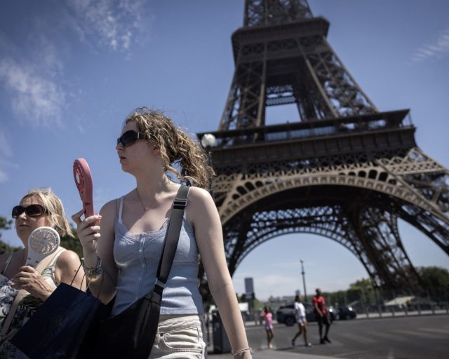 Women use electric fans to cool off during a heatwave in Paris on July 10, 2026. (Photo by Behrouz MEHRI / AFP via Getty Images)