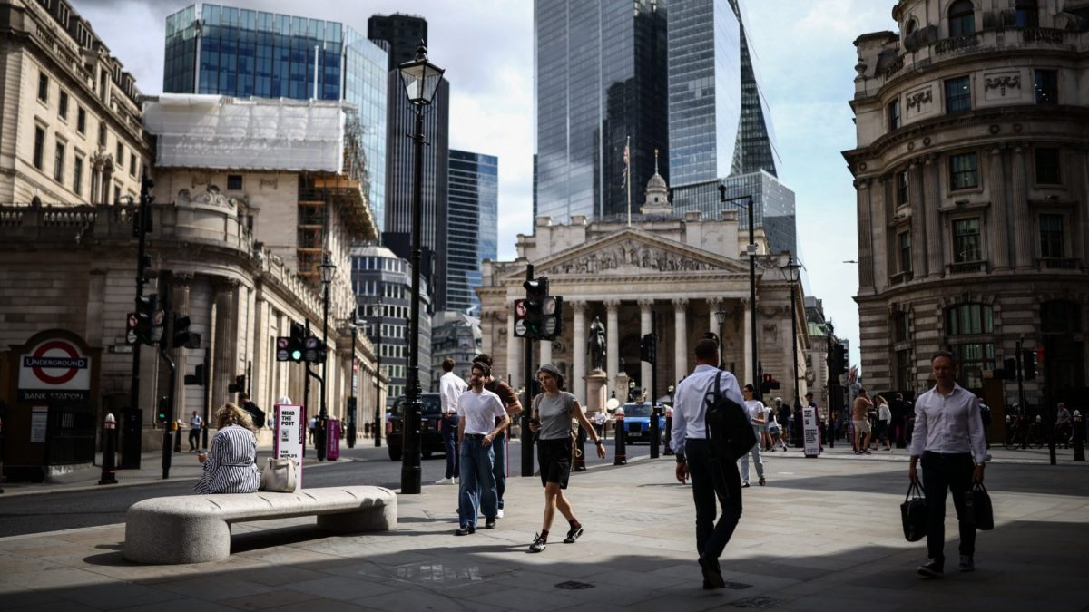 Pedestrians walk outside the Bank of England (back L) in the financial district in London on July 30, 2026. The Bank of England held its benchmark interest rate at 3.75 percent on July 30 but warned of higher inflation to come owing to the US-Iran war pushing up energy prices. (Photo by Henry NICHOLLS / AFP via Getty Images)