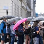 LONDON, ENGLAND - AUGUST 20: Tourists on a walking tour of Central London carry umbrellas during a heavy rain shower next to Pall Mall on August 20, 2026 in London, England. Heavy rain is unlikely to break England's widespread drought. Rain falling on the dry, baked soil could cause flash flooding rather than replenishing water supplies. With 71% of the country in drought, sustained rain over several months is required, meaning hosepipe bans will likely remain in place. (Photo by James D. Morgan/Getty Images)