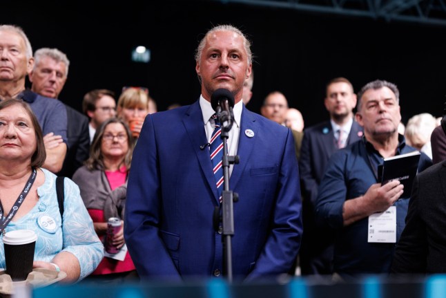 BIRMINGHAM, ENGLAND - SEPTEMBER 05: Co-founder of Raise the Colours, Ryan Bridge, asks a question as UK Party Leader Nigel Farage participates in a discussion with Jeremy Kyle (not pictured) during day two of the Reform UK party conference at the National Exhibition Centre on September 05, 2026 in Birmingham, England. Reform UK enters its September 2026 annual party conference facing a recent dip in opinion polls, dropping to 22%???23% in national voting intention after peaking at 28% in May. For the first time in over 18 months, the party has slipped behind the Conservatives into third place in select polling, squeezed by a resurgent Labour Party under Prime Minister Andy Burnham and new competition on the right. (Photo by Dan Kitwood/Getty Images)