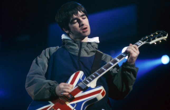 UNITED KINGDOM - APRIL 01: MAINE ROAD Photo of OASIS and Noel GALLAGHER, Noel Gallagher performing on stage, Union Jack Epiphone guitar (Photo by Patrick Ford/Redferns)