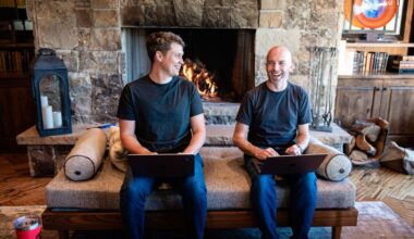 Thatch founders sitting on couch in front of fireplace