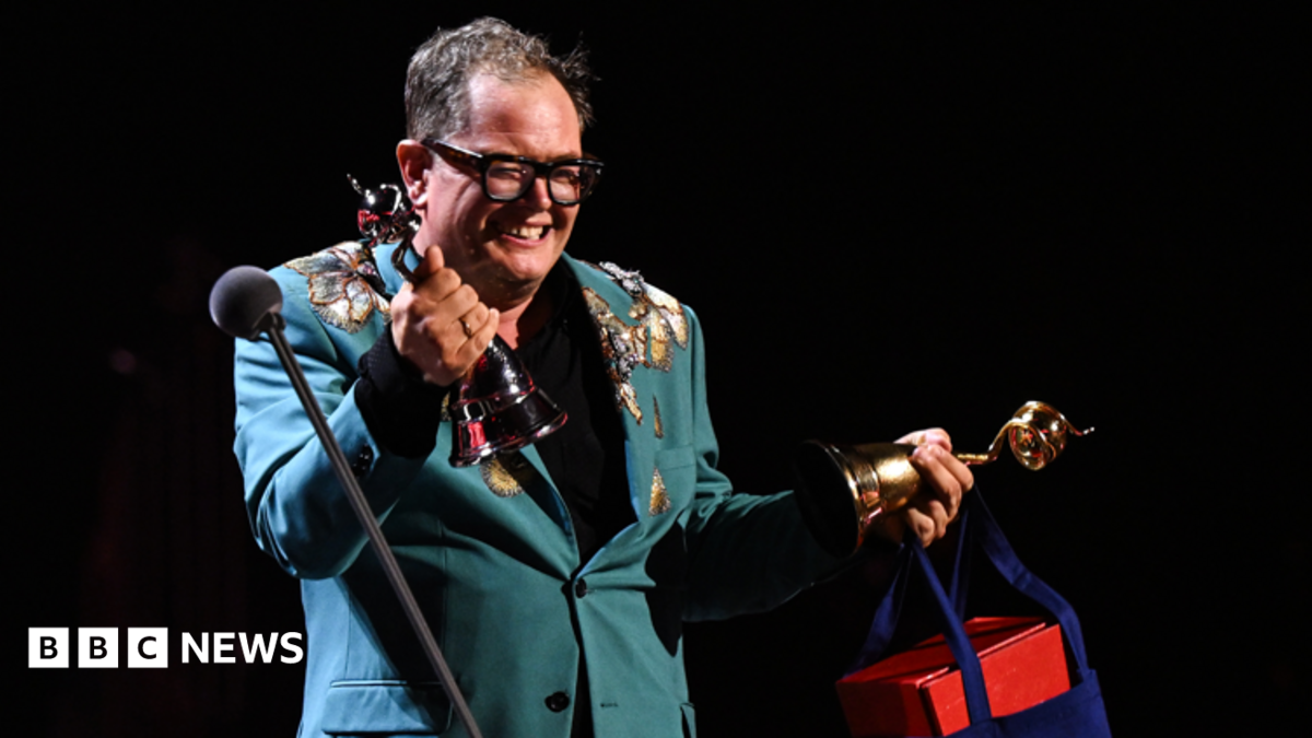 Alan Carr accepts the 'Special Recognition' award on stage during the National Television Awards 2026 show at The O2 Arena.
