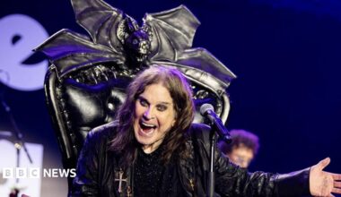 Ozzy Osbourne on stage with his arms outstretched and smiling