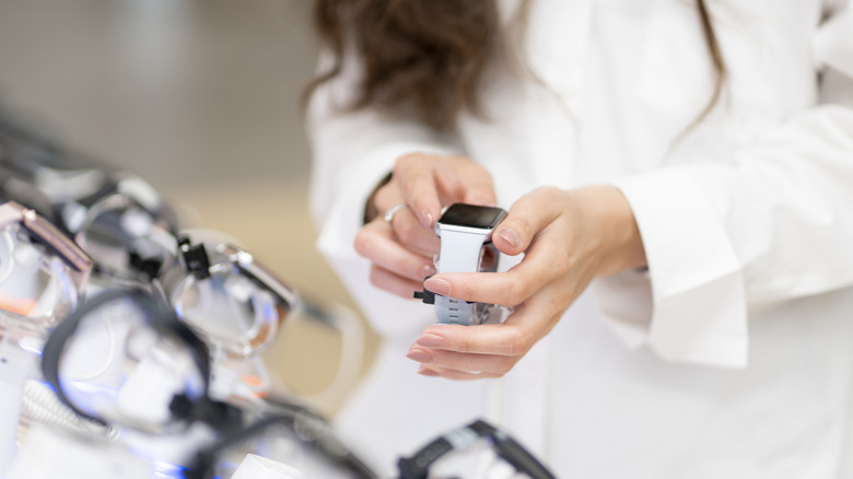 A woman inspecting a smartwatch in a store.