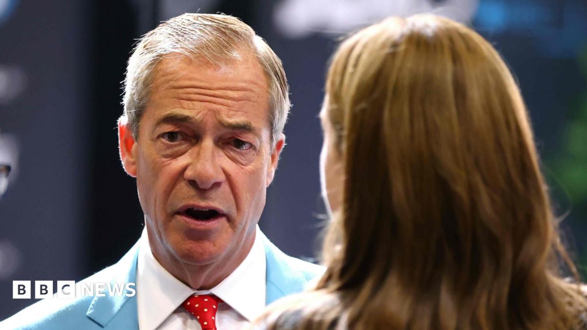 Farage, seen from the shoulders up and wearing a light blue suit and red polka dot tie, talks to a woman with long brown hair who is seen from behind.