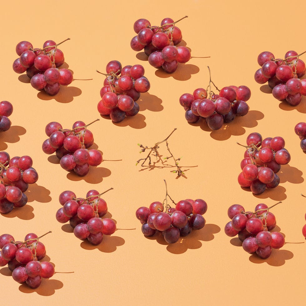 Grapes a group of grapes laid in a pattern on a colorful background, one bunch is eaten