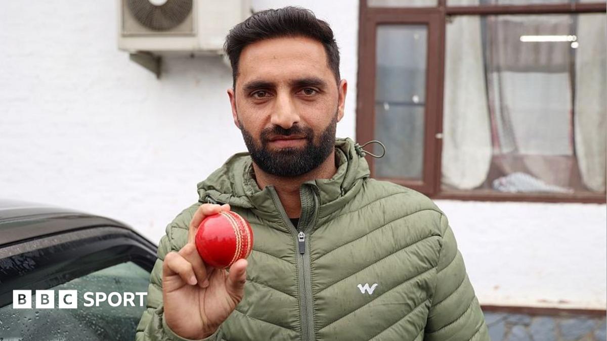 Auqib Nabi holds up a red ball