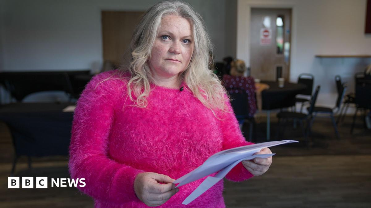 Sam, a resident of Thornton-Cleveleys, holds the blood test results printed on a white piece of paper. She is wearing a bright pink top.