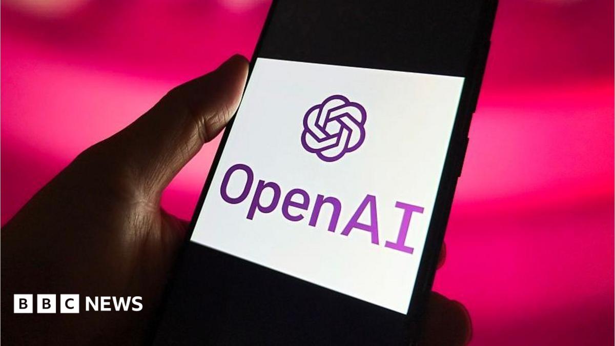 A hand holds a phone which has the OpenAI logo on its screen.