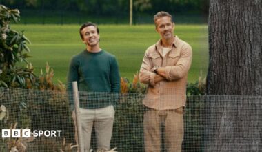 Rob Mac and Ryan Reynolds stand next to a tree