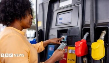 A woman pays for fuel at a gas station with her bank card