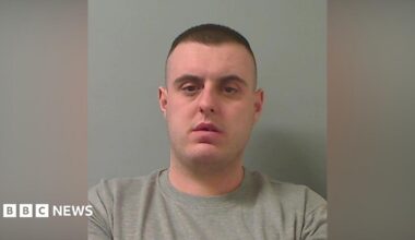 Mugshot of man with short dark hair and a grey sweater