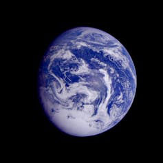 The Earth from afar, showing swirls of white on blue.