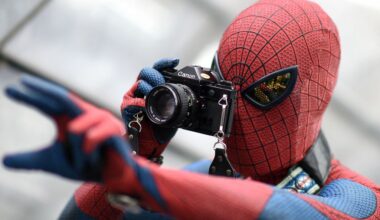 A visitor in a costume of fictional superhero Spiderman takes pictures during the Leipzig Book Fair on March 14, 2015.