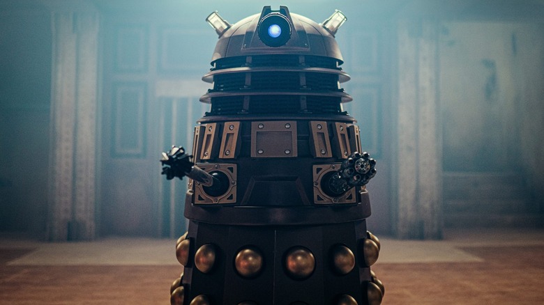 A Dalek Executioner looms in a shadowy hallway on Doctor Who.