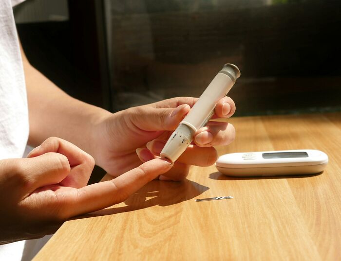 A person checking blood sugar levels, a contrast to outdated medical practices.