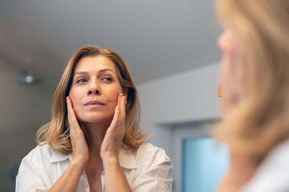 Middle age woman touching face