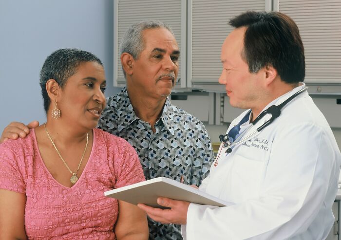 A doctor consulting with a senior couple, showcasing modern medical practices.