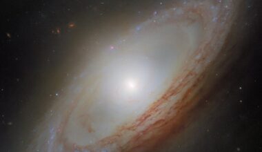 The spiral galaxy NGC 4698 is a member of the Virgo Cluster of galaxies. Its serene vision hides the fact that it has a tail of hydrogen gas stretching away from it; the spin of its arms is decoupled from the spin of the stars and gas in the center, and its bulge stretches out in an odd shape. Credit: ESA/Hubble &amp; NASA, D. Thilker, the MAUVE-HST Team
