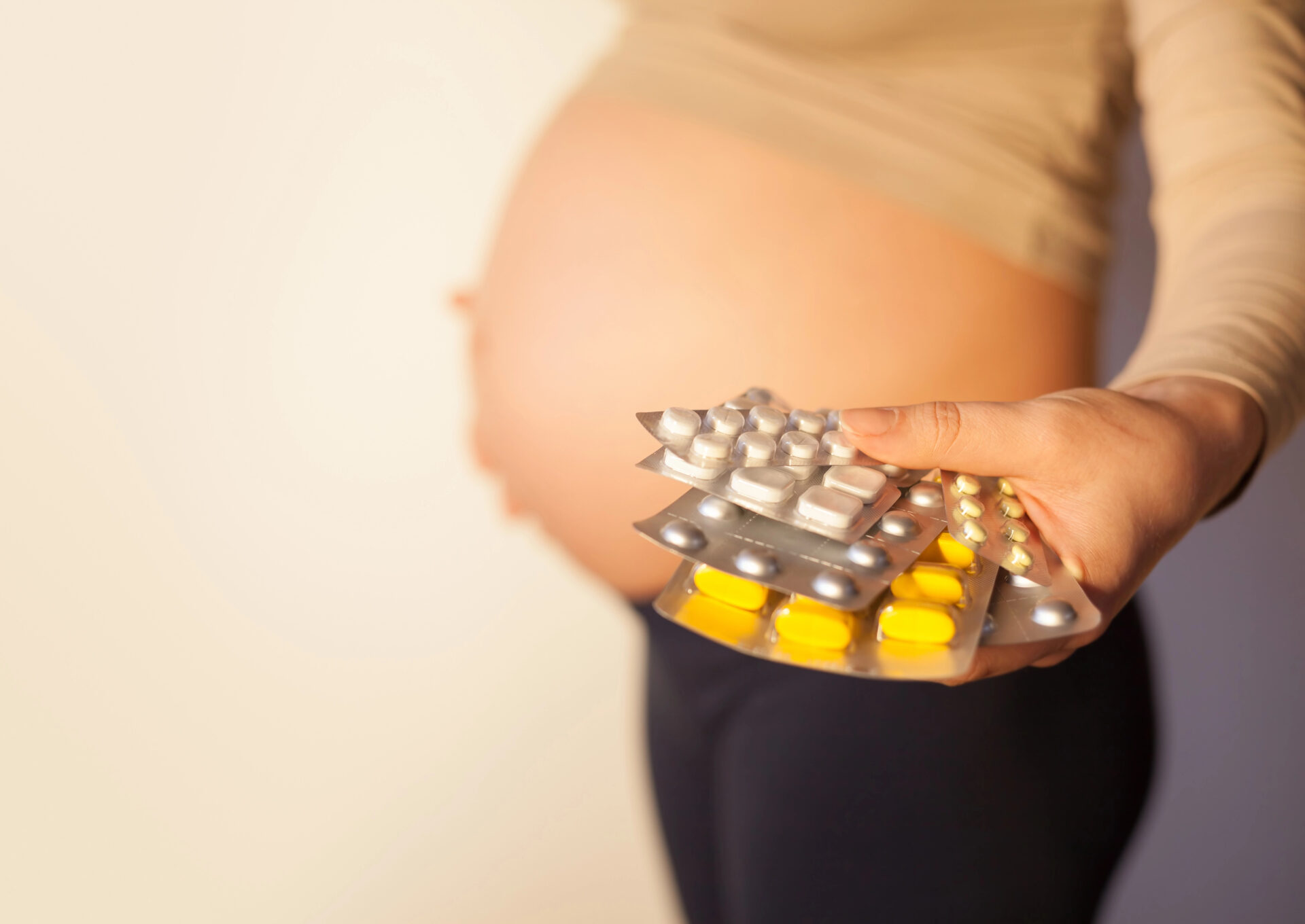 Prenatal vitamins being held by pregnant woman