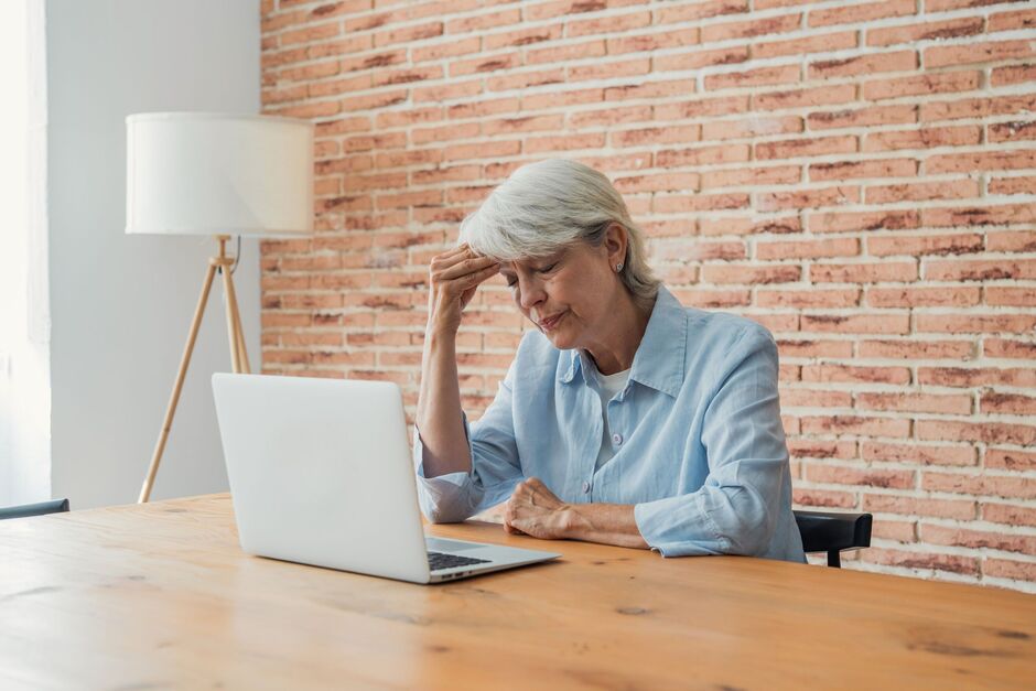 Senior woman working on a laptop at home office looking stressed and frustrated Senior woman working on a laptop at home office looking stressed and frustrated