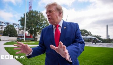 Trump standing and gesturing with his hands as he leaves the White House