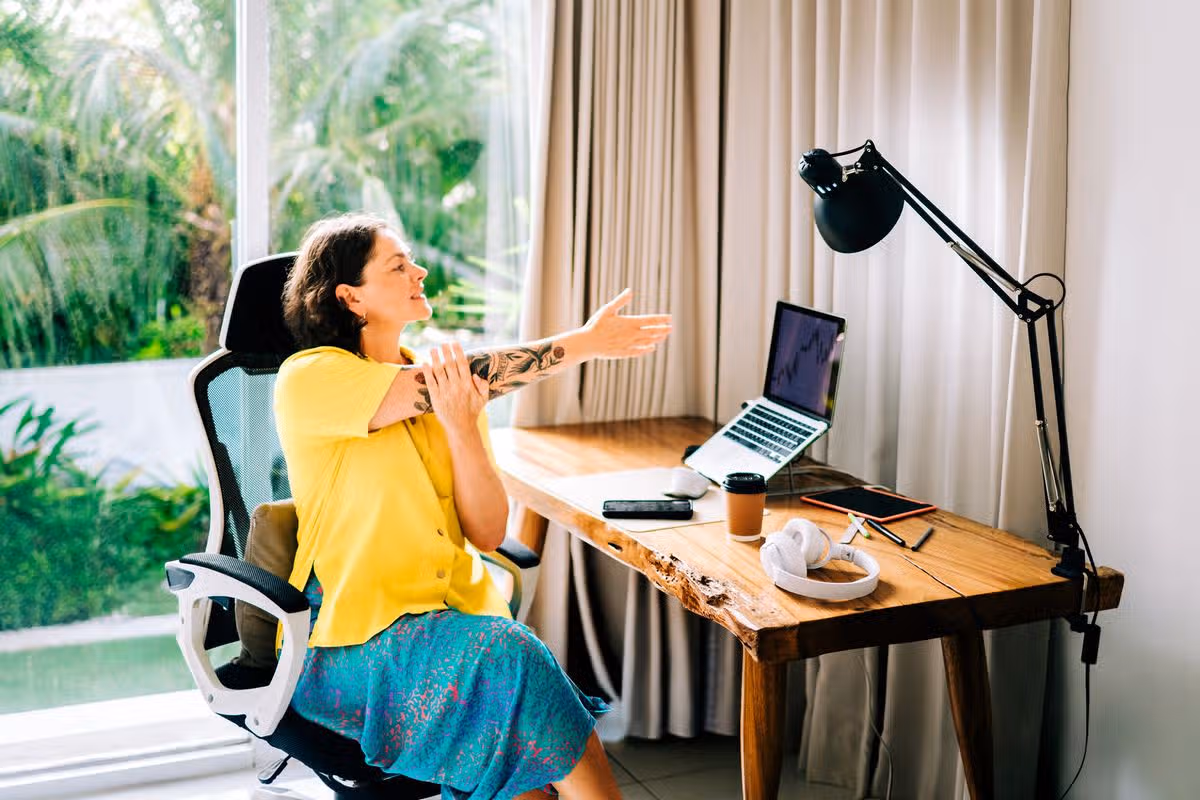 Woman stretching while working remotely at home office