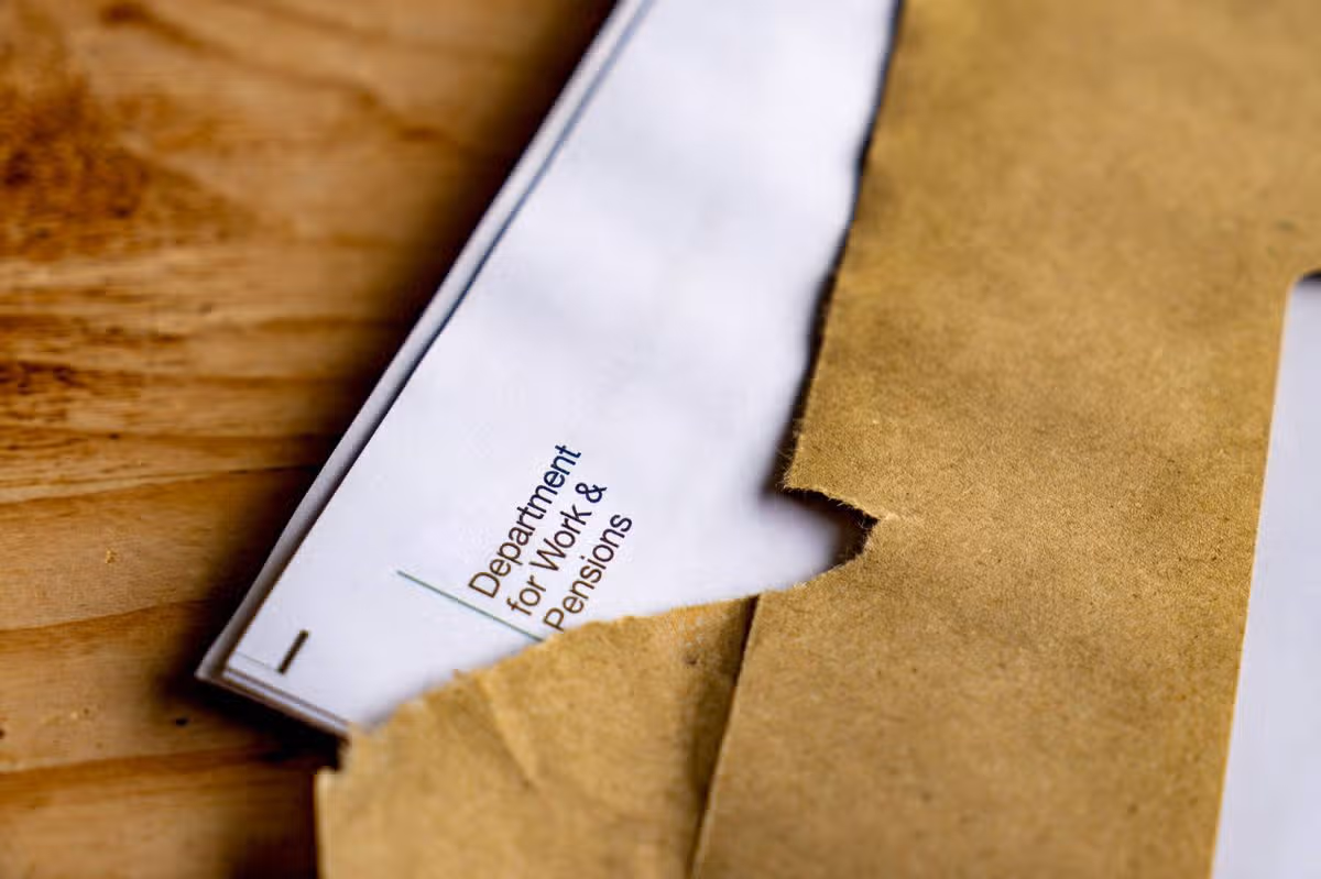 Opened Envelope with State Pension Increase Notification on Wooden Surface