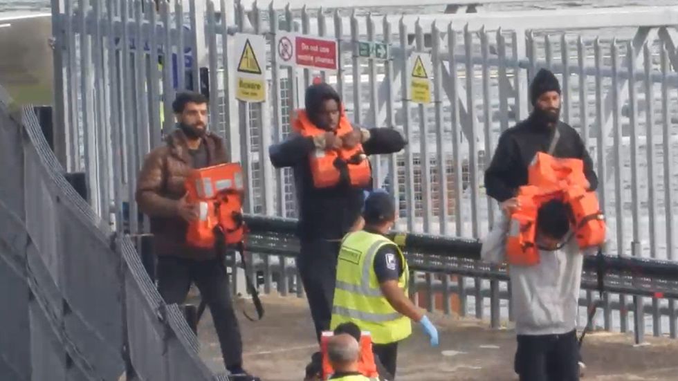 Migrants disembarking from a Border Force vessel