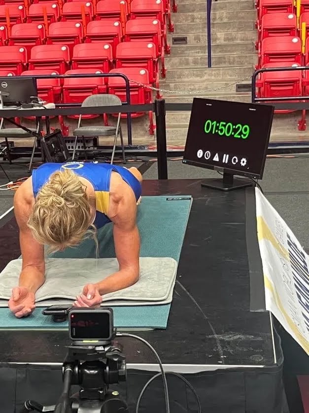 A woman on an exercise mat with a timer beside her