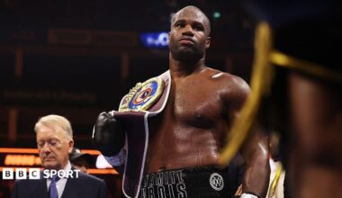Daniel Dubois has the WBO heavyweight title on his shoulder as Frank Warren stands in the background