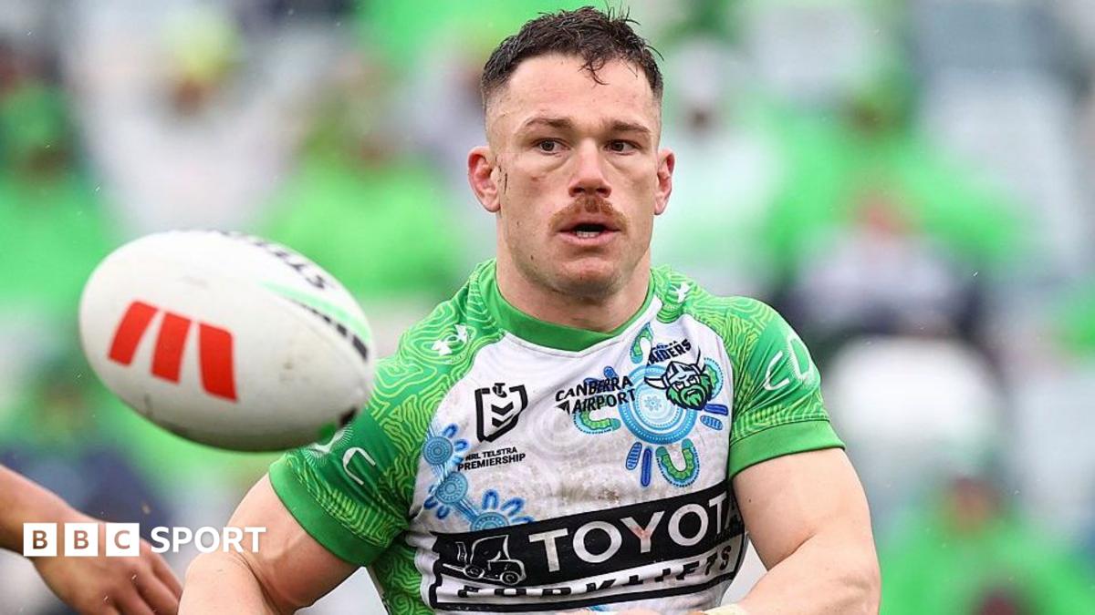 Tom Starling, in Canberra Raiders' white and green shirt, makes a pass