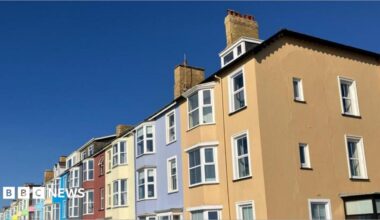 A row of colourful terraced houses under a bright blue sky.