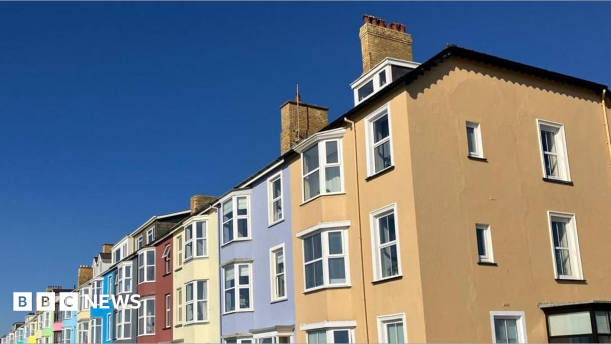 A row of colourful terraced houses under a bright blue sky.