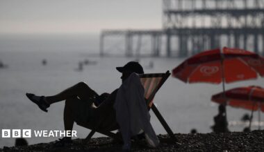Man sits in deckchair on Brighton beach during early September heatwave
