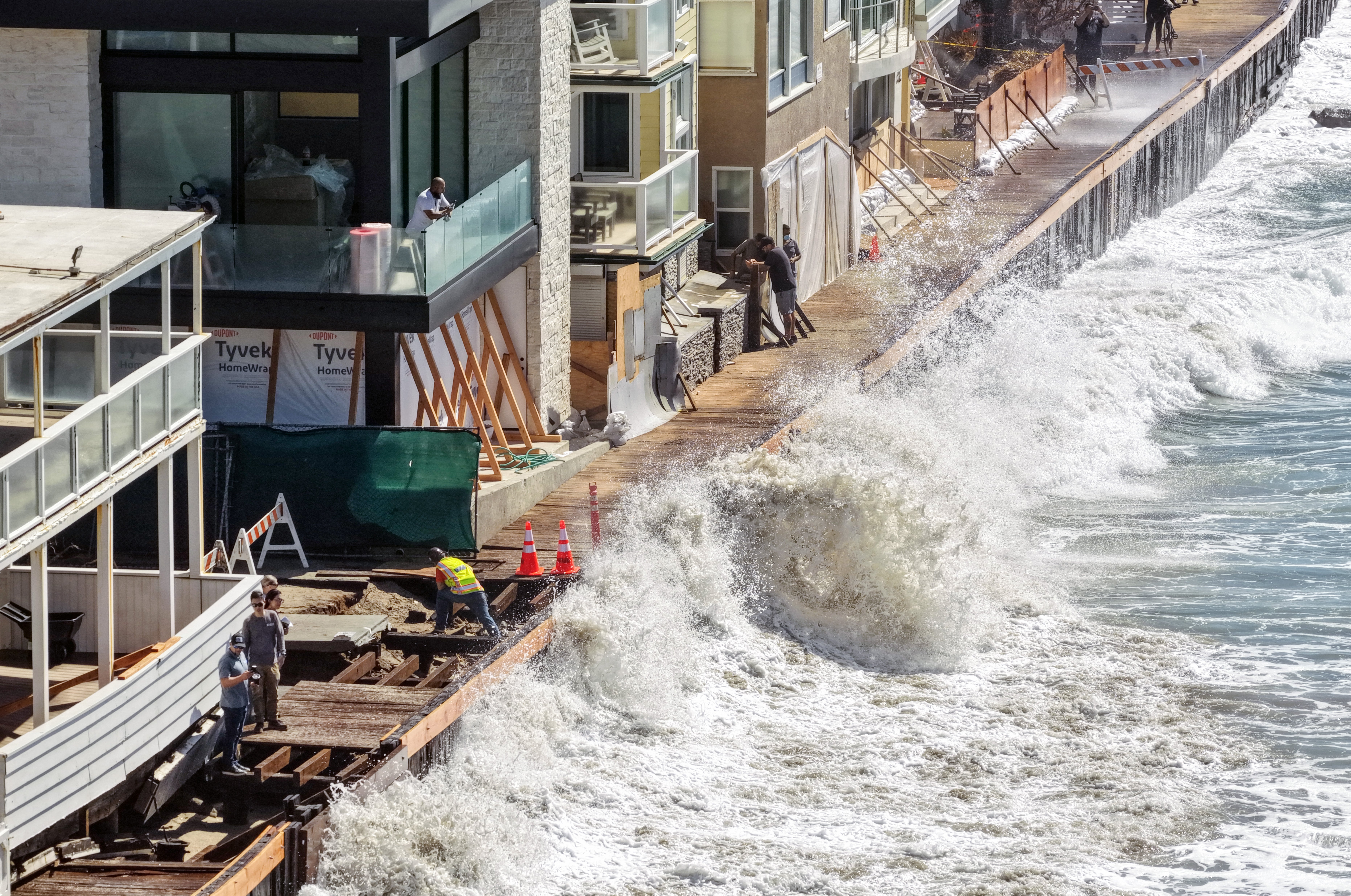 A wave crashes into a seawall protecting beachfront homes on Monday in Long Beach, California. A massive wave of energy is expected to send Pacific sea levels rising along the coast