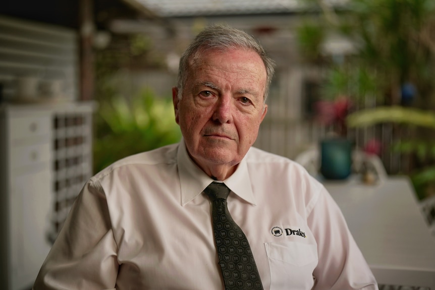 an older man in a supermarket uniform